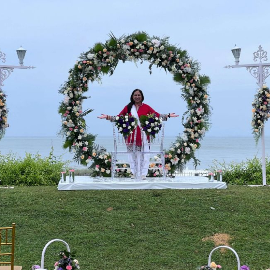 Sonal standing at wedding alter in front of ring of flowers